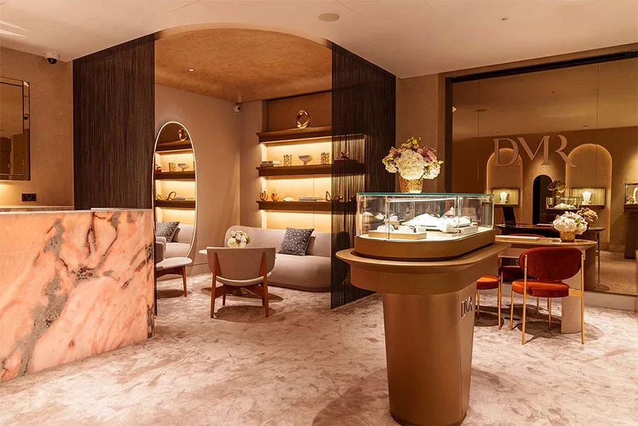 Jewellery boutique with pink onyx counter, warm timber partitions, and softly lit glass display cabinets